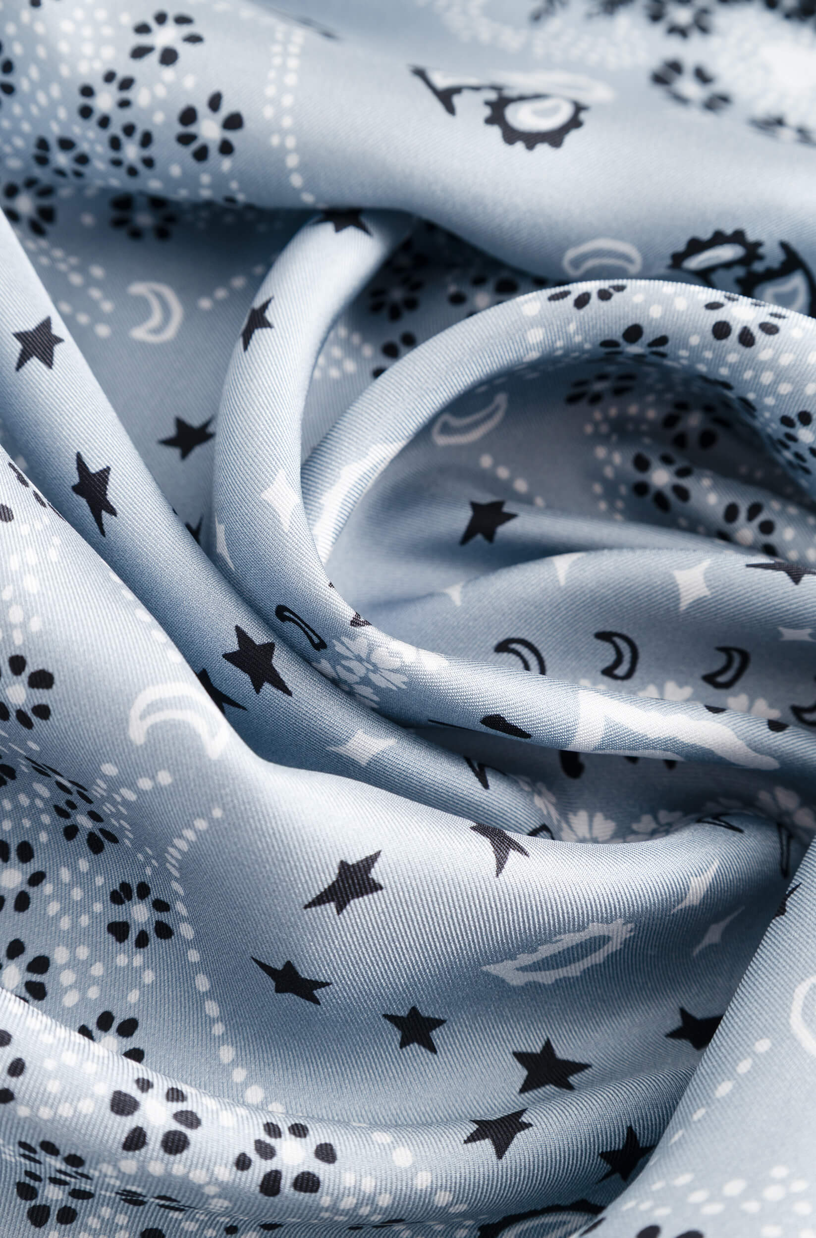 Détail avec texture du foulard en soie bleu glacier à motif bandana