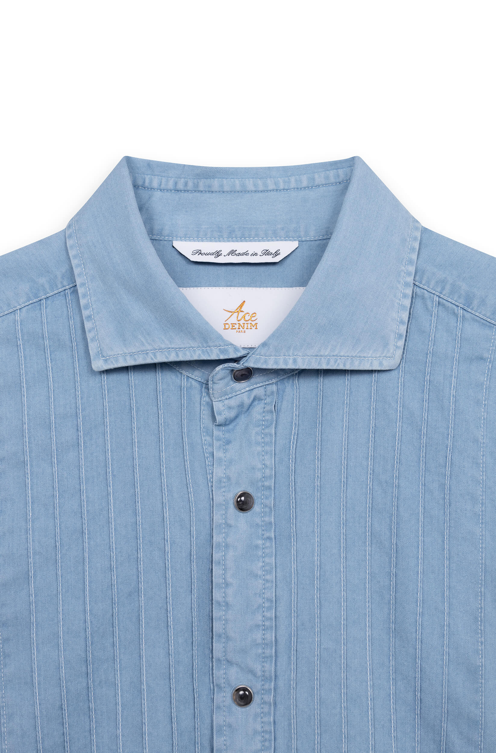 Close-up of the spread collar and pleated bib of the light blue cotton tuxedo shirt.