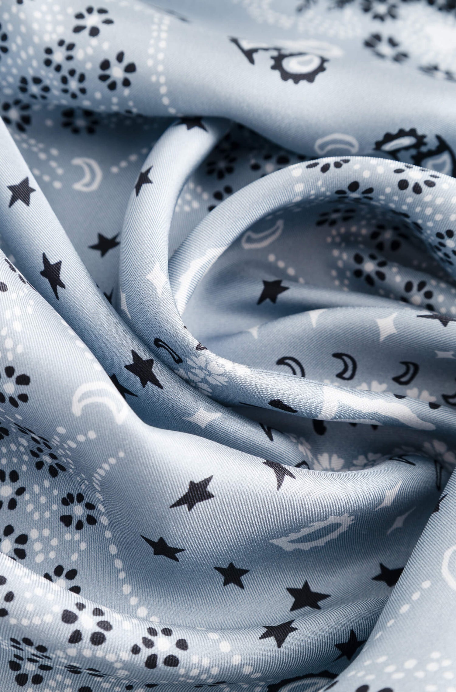 Détail avec texture du foulard en soie bleu glacier à motif bandana