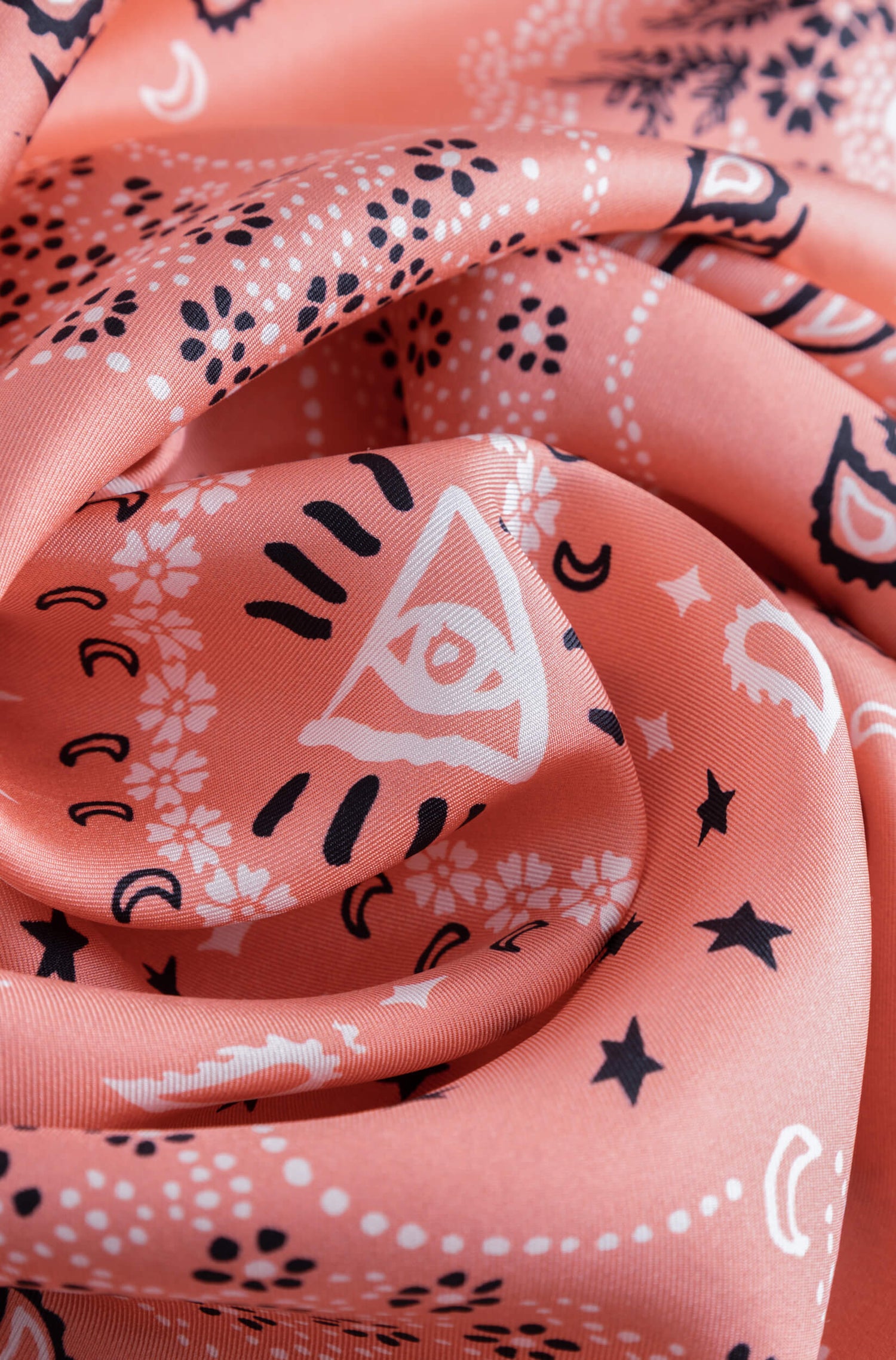 Détail avec texture du foulard en soie corail à motif bandana