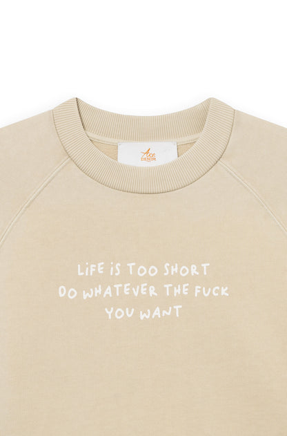 Zoom de face du sweat-shirt en coton beige teint artisanalement avec la phrase "life is too short, do whatever the f*** you want"