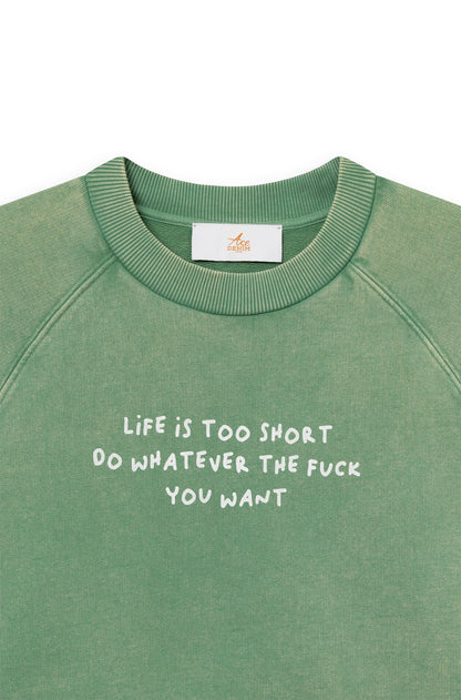Zoom de face du sweat-shirt en coton vert teint artisanalement avec la phrase "life is too short, do whatever the f*** you want"